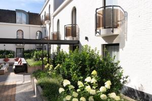 a courtyard of a building with a garden at Dukes' Academie Brugge - by Dukes' Hotel Collection in Bruges