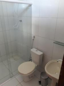 y baño con aseo, ducha y lavamanos. en Chalés Rosados en Serra de São Bento