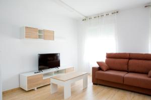 ein Wohnzimmer mit einem Sofa und einem TV in der Unterkunft Apartamento Completo Luna Llena de Calasparra in Calasparra