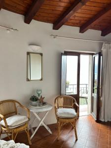 ガルニャーノにあるCasa Zuinoの椅子2脚、テーブル、窓が備わる客室です。