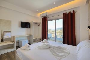 a bedroom with a large white bed with a window at Galaxy Hotel in Ksamil +72 photos