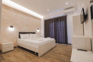 a bedroom with a white bed and a large window at Galaxy Hotel in Ksamil