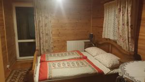 een kleine slaapkamer met een bed en een raam bij Wynajem pokoi-Burniszki in Burniszki
