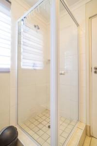 a shower with a glass door in a bathroom at The Rondebosch in Cape Town