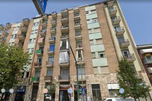 a large brick building with windows on a street at BnB Arianna's home in Turin