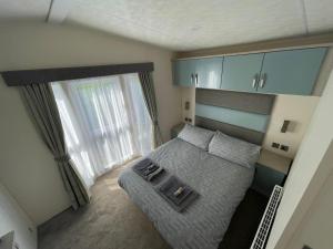a small bedroom with a bed and a window at Lake District Luxury Lodge in Plumbland