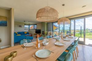 a dining room with a long table and chairs at Natuurvilla 14 Westerkolk in De Waal
