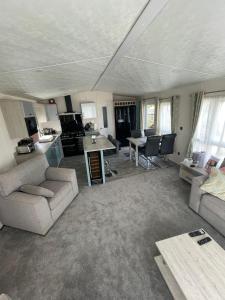 un ampio soggiorno con divano e tavolo di Lake District Luxury Lodge a Plumbland