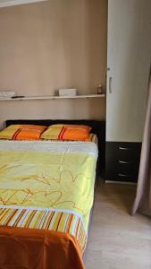 ein Schlafzimmer mit einem Bett mit orangefarbenen Kissen darauf in der Unterkunft Apartman Batuta in Budva
