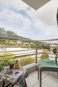 a balcony with a table and a view of mountains at The Rondebosch in Cape Town