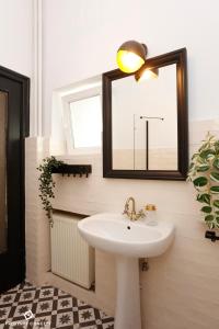 uma casa de banho com um lavatório e um espelho em Bohemian Central Concept Studio em Bucareste