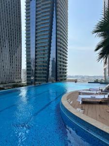 a large swimming pool in a city with tall buildings at LUXURY 1 BR Apartment at Marina Gate Jumeirah Living in Dubai