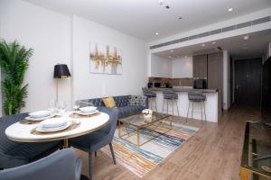 a living room with a table and chairs and a kitchen at LUXURY 1 BR Apartment at Marina Gate Jumeirah Living in Dubai