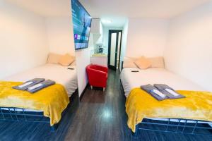 two twin beds in a room with a tv at Stunning 1-Bed Studio in Birmingham available in Birmingham