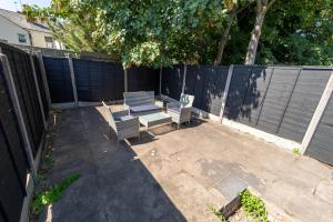 a patio with two benches and a fence at Stunning 1-Bed Studio in Birmingham available in Birmingham