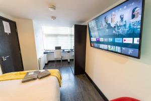 a room with a large tv on the wall at Stunning 1-Bed Studio in Birmingham available in Birmingham