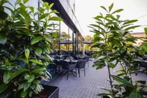a patio with tables and chairs and plants at Hermanns Hotel & Spa Sibiu in Sibiu