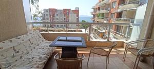 laptopa siedzącego na kanapie na balkonie w obiekcie Cozy apartment with sea view w mieście Pomorie