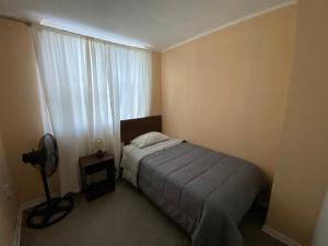 - une petite chambre avec un lit et une fenêtre dans l'établissement Departamento familiar, à Curicó