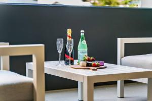 una mesa con una botella de vino y una copa en Elegance on Pine - by Coast Hosting, en Terrigal