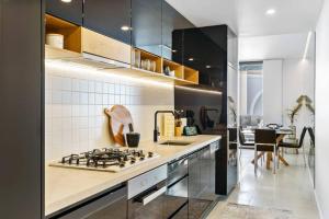 a kitchen with a stove and a counter top at Elegance on Pine - by Coast Hosting in Terrigal