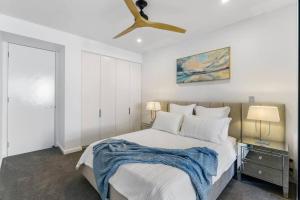 a bedroom with a bed with a ceiling fan at Elegance on Pine - by Coast Hosting in Terrigal