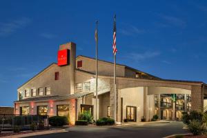 a building with an american flag in front of it at Ramada by Wyndham Albuquerque Airport in Albuquerque