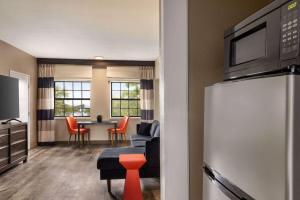 a living room with a kitchen and a dining room at Ramada by Wyndham Albuquerque Airport in Albuquerque