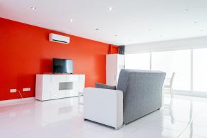ein Wohnzimmer mit einem Stuhl und einem TV in der Unterkunft Playa 4 a solo 3 min - Apartamento en Castelldefels in Castelldefels