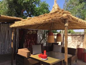 mesa con sombrilla de paja, mesa y sillas en Villa 202 commentaires 5 étoiles sur 3 sites, en Essaouira
