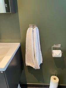 a bathroom with white towels hanging on a wall at Nybyggt gästhus nära havet och Göteborg in Kullavik