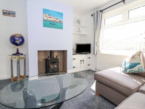 ein Wohnzimmer mit einem Glastisch und einem Sofa in der Unterkunft Wavecrest in Hornsea