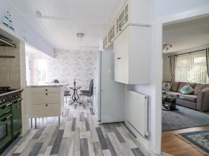 eine Küche mit einem Kühlschrank und ein Wohnzimmer in der Unterkunft Wavecrest in Hornsea