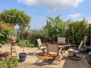 eine Terrasse mit Stühlen und einem Tisch im Garten in der Unterkunft Wavecrest in Hornsea