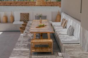 drewniany stół na patio z kanapą i stołem w obiekcie Athena Luxury Villa by Estia w mieście Gázion