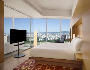 a bedroom with a large bed and a flat screen tv at Park Hyatt Seoul in Seoul