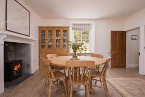 uma sala de jantar com uma mesa e cadeiras e uma lareira em Lonach Coaching Inn 