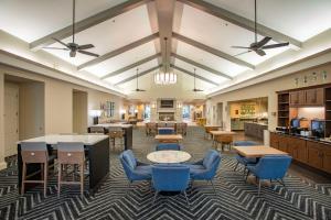 a lobby with tables and chairs and a cafeteria at Homewood Suites by Hilton Pensacola Airport-Cordova Mall Area in Pensacola