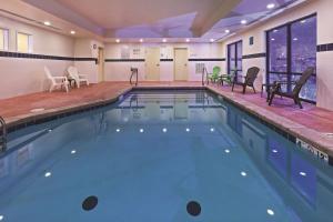 a large swimming pool with chairs and tables in a building at La Quinta by Wyndham Edmond in Edmond