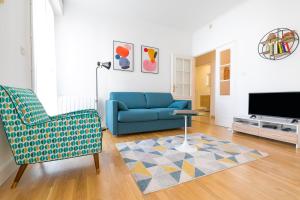 a living room with a blue couch and a tv at 56-chabot-charny in Dijon