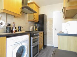 a laundry room with a washer and dryer in a kitchen at Tudors eSuites 4 Bedroom House 9 Bed with Garden in Parkside