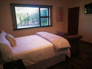 a bedroom with a large bed and a window at Sleep Haven in Johannesburg