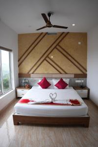 1 dormitorio con cama con almohadas rojas y techo en Sapphire Mansion Vagamon, en Vagamon