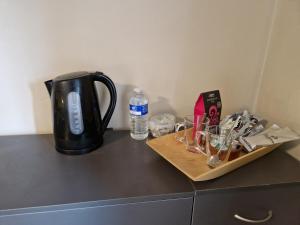 a coffee pot on a counter with glasses and water at Cosy Riverside home in Llanwrda