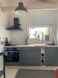 a kitchen with a stove and a sink and a window at Silja in Pärnu