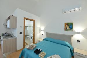 - une chambre avec un lit bleu et un lavabo dans l'établissement L'Antico Palazzo, à Canosa di Puglia