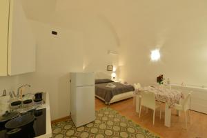 - une cuisine avec un lit et une table avec des chaises dans l'établissement L'Antico Palazzo, à Canosa di Puglia