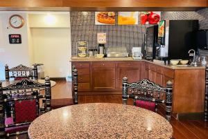 a kitchen with a table and chairs and a counter at Super 8 by Wyndham Gloucester in Gloucester City