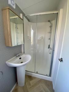 a bathroom with a sink and a shower at Hafan Y Môr Caravan - Pwllheli in Chwilog