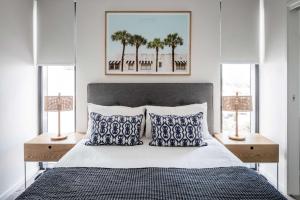 una camera da letto con un letto con cuscini blu e bianchi di First Light Mooloolaba, Ascend Hotel Collection a Mooloolaba